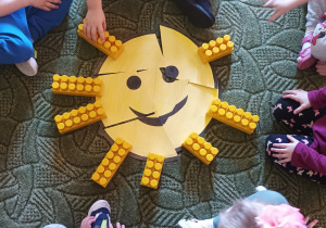 Dzieci układają słońce z elementów